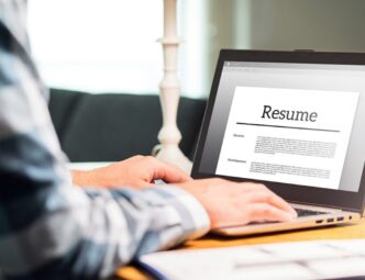 male sitting at computer with resume on the screen